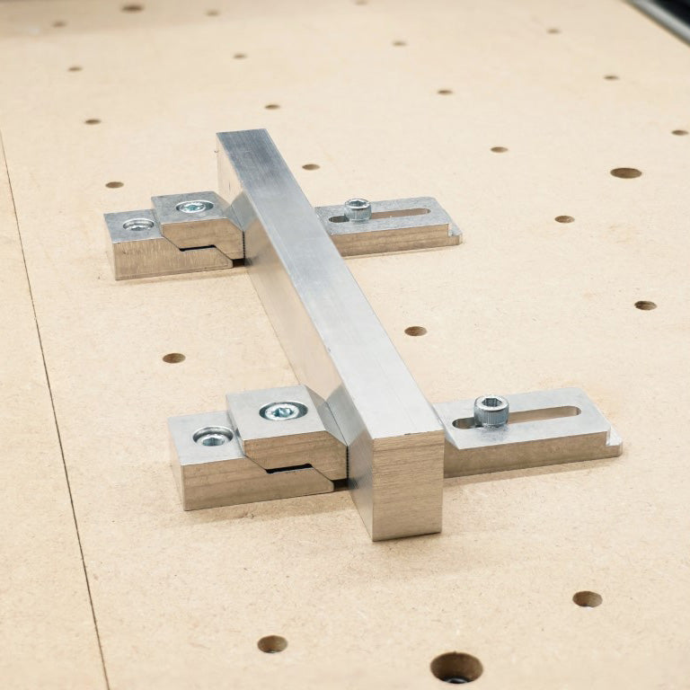 2 edge clamps and 2 top clamps holding an aluminium bar