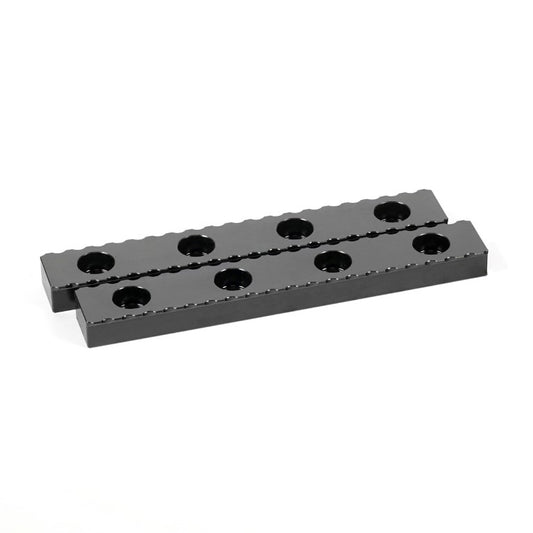 A black serrated gripper made of hardened steel, with multiple holes along its length for clamping purposes.
