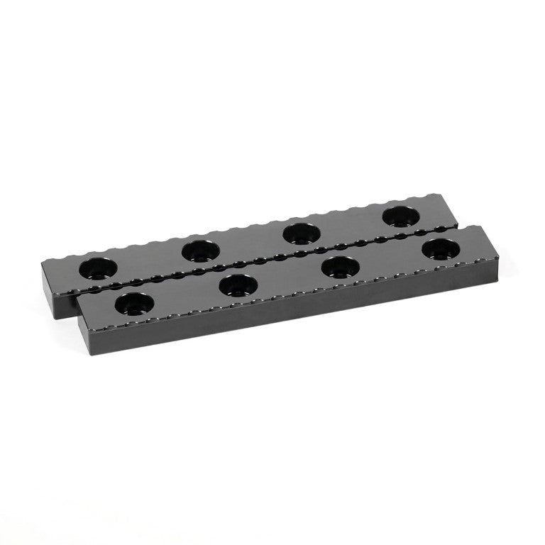 A black serrated gripper made of hardened steel, with multiple holes along its length for clamping purposes.
